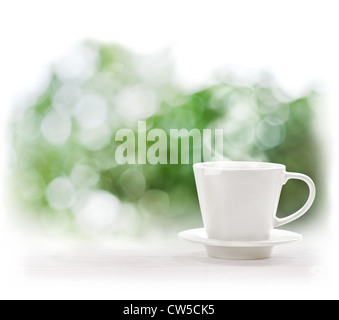 Tasse de boisson chaude sur fond d'été flou artistique Banque D'Images