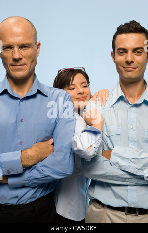 Businesswoman poussant son chemin entre deux hommes d'affaires Banque D'Images