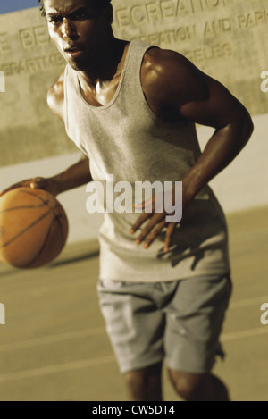 Jeune homme dribbler un basket-ball Banque D'Images