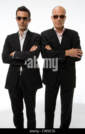 Homme mûr et un jeune homme portant des lunettes de soleil avec leurs bras croisés Banque D'Images