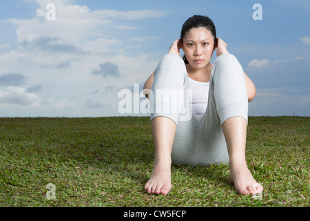 Femme chinoise faisant asseoir ups dans parc. Banque D'Images
