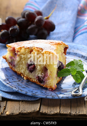 Gâteau éponge avec raisins rouges sur une plaque Banque D'Images