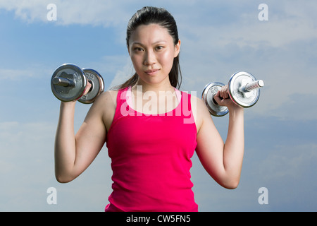 Chinese woman exercising with dumbbells Banque D'Images