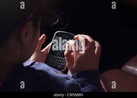 Les textes de l'enfant sur un téléphone intelligent Blackberry Banque D'Images