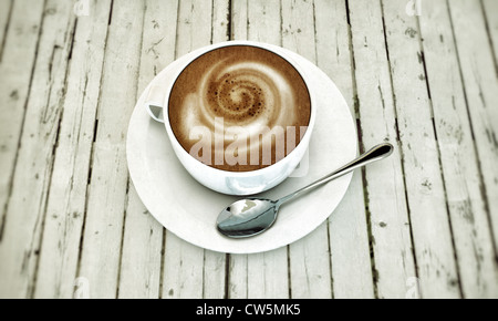 En cappuccino chaud tasse en céramique blanche sur tableau blanc en bois Banque D'Images