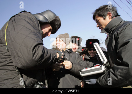 Les touristes de Beijing sont l'achat d'un marchand dans la rue battant Banque D'Images