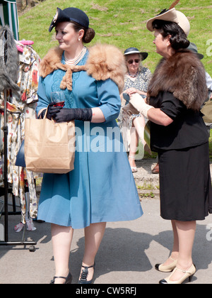 Deux femmes vêtues de vêtements des années 40, shopping, reconstitution d'un week-end à Uppermill, Greater Manchester, UK. Banque D'Images