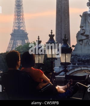 Vue arrière du couple dans le parc près de la Place de la concorde avec la Tour Eiffel au coucher du soleil à Paris Banque D'Images