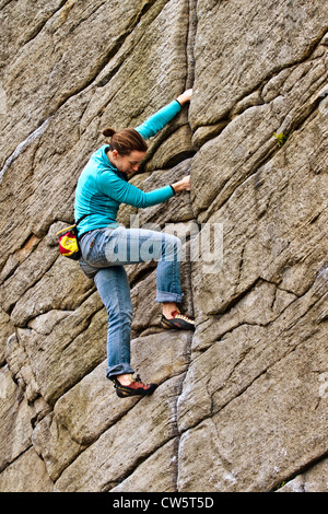 Une jeune femme rock monte une fissure à Burbage, Sheffield, près de Stanage dans le Peak District National Park, Angleterre, Royaume-Uni, Europe Banque D'Images