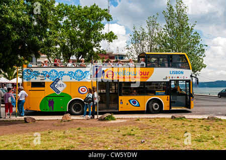 Un bus jaune officiel peint de couleurs vives, rempli de passagers a un petit arrêt à une destination touristique populaire de Lisbonne, Belém Banque D'Images