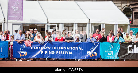 Public pour une performance à George Square, derrière une bannière pour le Live !, Festival International de Glasgow Piping. Banque D'Images