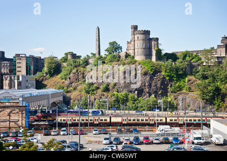 Train de l'entrée de la gare de Waverley à Édimbourg ; Maison du Gouverneur et le Monument des Martyrs Politiques sur Calton Hill. Banque D'Images