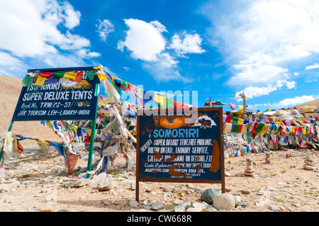 Deux panneaux ornés de drapeaux de prière publicité Tsomoriri Super Deluxe tentes au Col Namshangla au Ladakh, Inde Banque D'Images