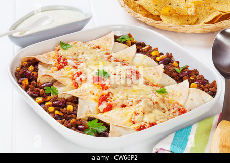 Boeuf enchiladas mexicaines et de maïs avec de la crème sure et les croustilles de maïs. Banque D'Images