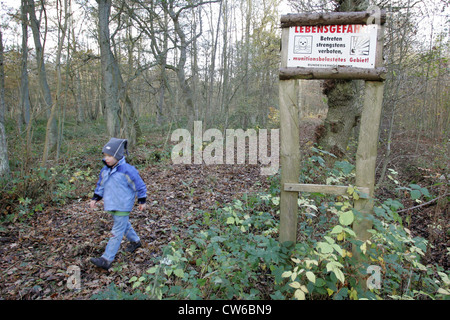 Zingst, un enfant s'exécute sur un sentier forestier avec le signe de danger Banque D'Images