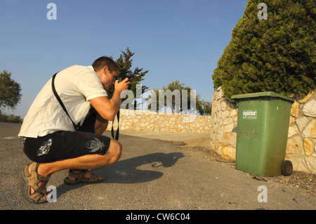 Jeune homme de prendre une photo d'une poubelle, Grèce, Péloponnèse Banque D'Images