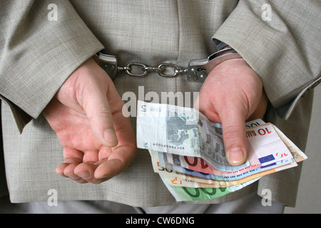 Menottés businessman holding euro factures dans sa main Banque D'Images