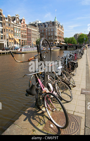 Vieux vélos garés sur une gracht dans le centre-ville d'Amsterdam, Pays-Bas Banque D'Images