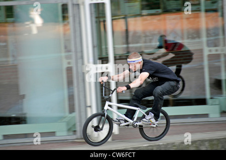 Le BMX-cycliste en face d'une fenêtre, l'Allemagne, en Rhénanie du Nord-Westphalie, Koeln Banque D'Images