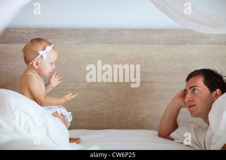 Jeune père et cute baby girl de parler les uns avec les autres dans le lit Banque D'Images