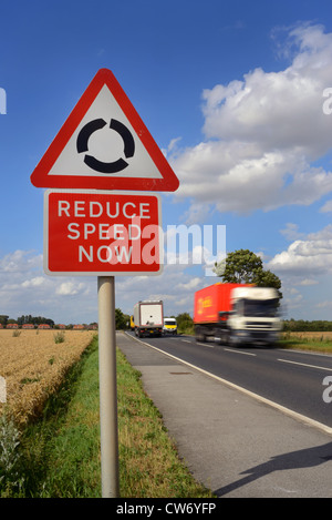 Réduire la vitesse de passage de camion maintenant avertissement et rond-point devant uk Banque D'Images