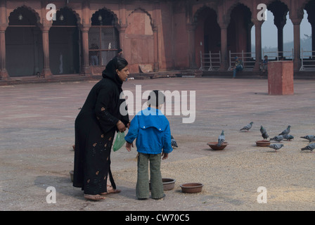 La mère et l'enfant à l'intérieur de la Jama Masjid. Ils transportent des graines d'oiseaux, utilisé pour nourrir les pigeons qui se trouvent dans le Jama Masjid. Banque D'Images