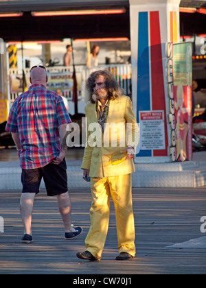 Un homme dans un costume jaune s'amuse sur la jetée de Brighton. Banque D'Images