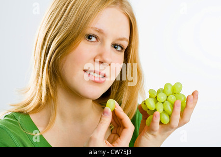 Jeune femme mange des raisins Banque D'Images