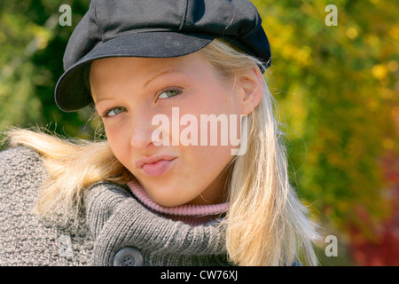 Jeune fille blonde sulky avec cap Banque D'Images