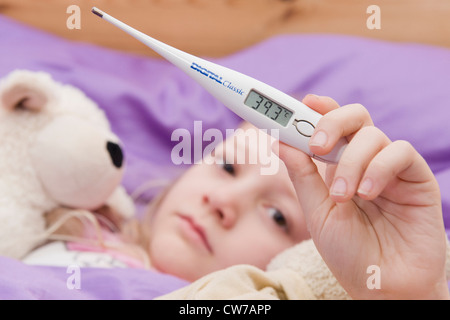 Sick girl avec thermomètre clinique au lit Banque D'Images