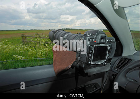 Appareil photo sur bean bag couché dans fenêtre ouverte d'une voiture, Pays-Bas, de Nijkerk Banque D'Images