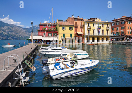 Promenade du port avec des bateaux à l'avant- et de montagnes à l'arrière-plan, l'Italie, le lac de Garde, Malcesine Banque D'Images