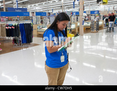 Les jeunes femmes qui écrit les informations d'inventaire à un Wal-Mart Supercenter à San Marcos, Texas Banque D'Images