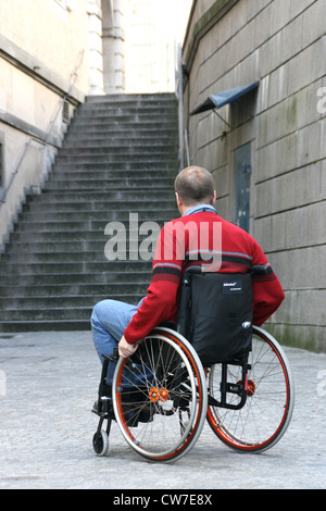 Homme d'attente dans un fauteuil en face d'un escalier Banque D'Images