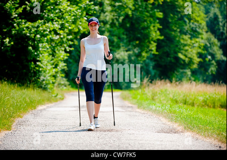 Jeune femme au cours de la marche nordique Banque D'Images