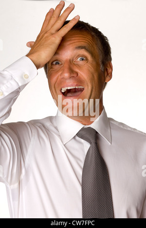 Old man avec une chemise blanche et cravate est frapper sa main sur le front Banque D'Images