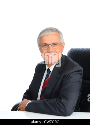 Portrait d'un homme d'âge mûr assis. L'homme est souriant et portant des lunettes, sur un fond blanc. Banque D'Images