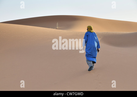 En costume traditionnel berbère marchant dans le désert, le Maroc, l'Erg Chebbi Banque D'Images