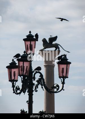 Oiseau vole sur le lion ailé Colonne et lampadaire dans la Piazetta di San Marco (la Place St Marc) Banque D'Images