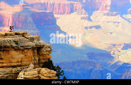 Un photographe prend des photos à partir d'un point rocheux surplombant la rive sud du Grand Canyon Banque D'Images