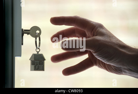 MANS HAND REACHING FOR HOUSE KEY FOB ET PORTE EN RE LES ACHETEURS DE PREMIÈRE FOIS L'ACHAT DE MAISONS MAISONS DE PRÊTS HYPOTHÉCAIRES DU MARCHÉ DU LOGEMENT Royaume-uni Banque D'Images