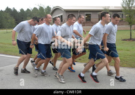 Les aviateurs du 20e Escadron de génie civil, ordonnance d'explosion, se rassemblent pour transporter un mannequin pendant la course de poker 5K à la base aérienne de Shaw, L.C., 10 août 2012. Ils ont formé le port du mannequin pour promouvoir le travail d'équipe et ont pratiqué le concept « ne laissez jamais un Airman derrière lui ». Pour soutenir cette croyance, ils ont porté le mannequin tout au long de la course de 3 ½ mile. Banque D'Images