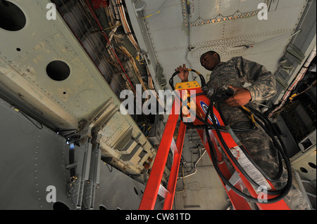 Avion 1er classe Gavin Moses, membre de l'équipage du chargement d'armes du 5e Escadron de maintenance d'aéronefs installe un câble pour effectuer une vérification opérationnelle du système d'armes classiques interne sur une B-52H Stratoforteresse à la base aérienne de Minot, N.D., le 10 août 2012. Dans le cadre du Commandement de la frappe globale de la Force aérienne, les chargeurs d'armes travaillent sans cesse pour préserver la sécurité de notre pays en fournissant des forces prêtes au combat pour la dissuasion nucléaire et les opérations de frappe mondiales. Banque D'Images