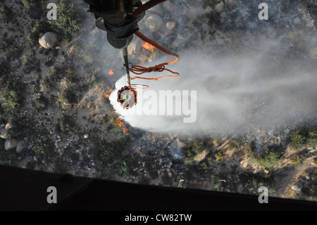 Des soldats de la Compagnie Alpha, 2e Bataillon, 285e Régiment d'aviation, de la Garde nationale de l'Arizona, déposent de l'eau sur le feu de Charley pendant les efforts de lutte contre les incendies le 14 août. Les aviateurs ont aidé les divisions forestières nationales et nationales à lutter contre le feu Charley près du lac Bartlett et le feu de crête erreur près du lac Roosevelt tout au long de la semaine. On prévoit que les équipages continueront de travailler sur les deux incendies jusqu'au reste de la semaine et peut-être jusqu'à la semaine prochaine. Banque D'Images