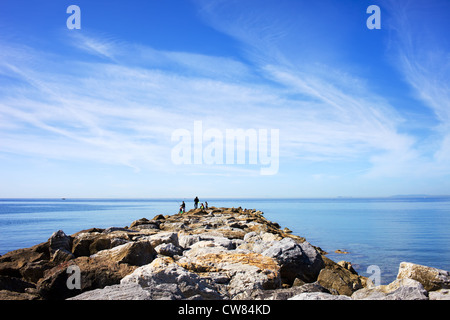 Bon nuages dans le ciel au-dessus des eaux calmes de la mer méditerranée avec rocky jetée à costa del sol à Marbella, Espagne. Banque D'Images