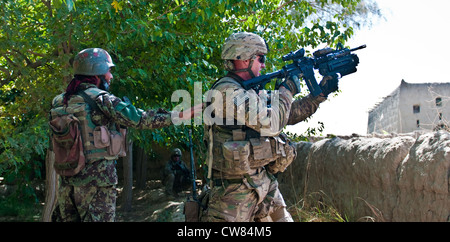 Un soldat de l'Armée nationale afghane se tient debout pour aider à signaler au Sgt. Cody Outcalt, soldat du 2e peloton, compagnie Apache, 1er Bataillon, 23e Régiment d'infanterie, où tirer son M320 lors d'un incendie avec des insurgés dans le sud de l'Afghanistan, le 30 juillet 2012. Banque D'Images