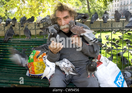 Paris, vieil homme nourrir les pigeons Banque D'Images