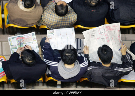 Hong Kong, les gens sont assis sur une tribune Banque D'Images