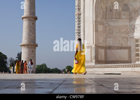 Femme en sari jaune marchant sur le sol en marbre à l'extérieur de l'hôtel Taj Mahal Banque D'Images