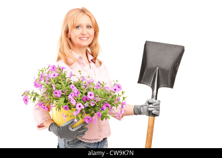 Un jardinier femelle holding Flowers et une pelle isolé sur fond blanc Banque D'Images